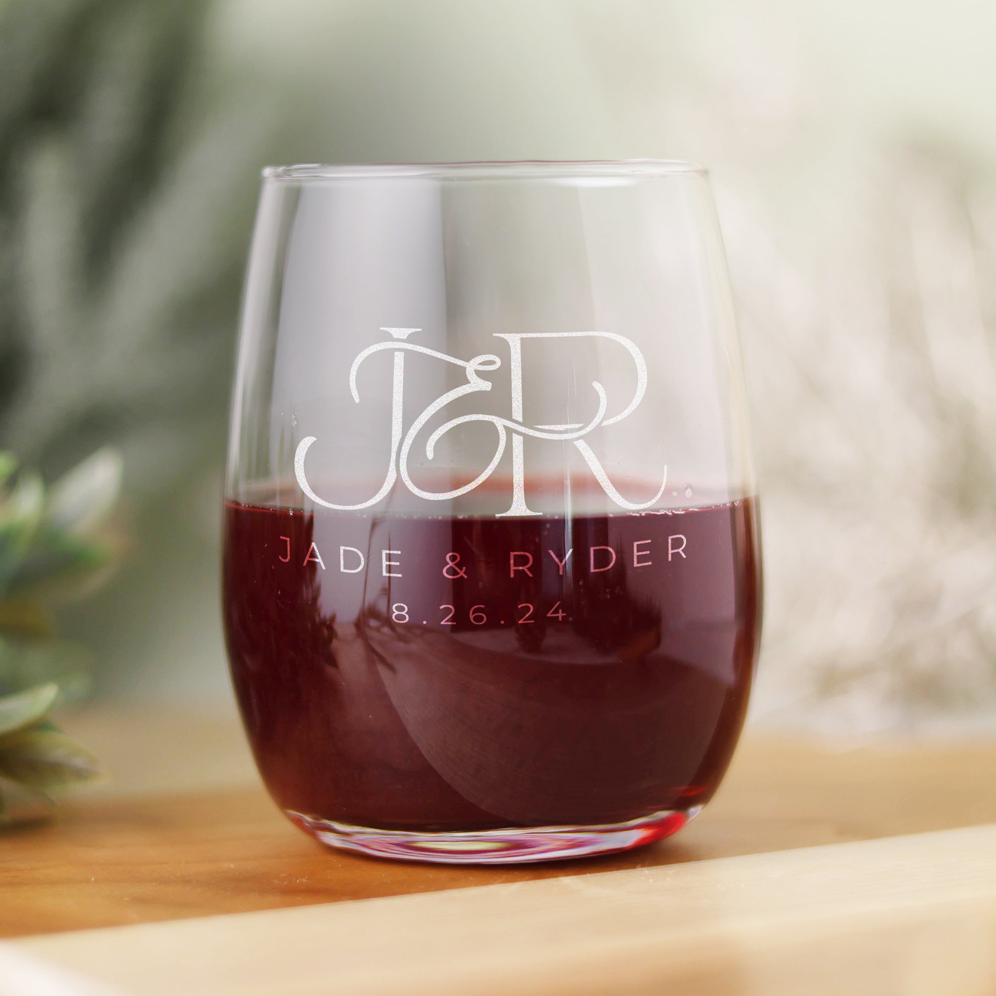 15oz wine glass with engraved initials and wedding date. the glass is half full. 