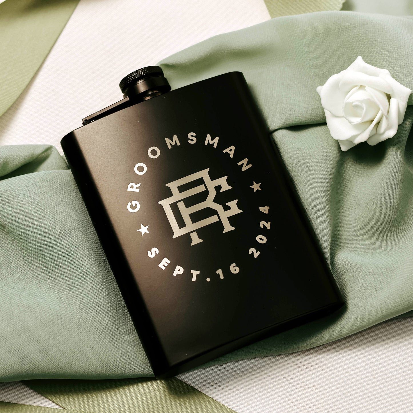 Black engraved 8oz flask with groomsman, initials, and wedding date. Top-down angle.