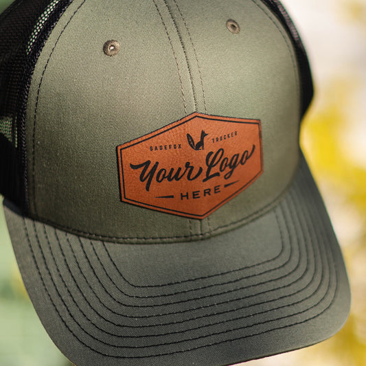 Green trucker hat with engraved leatherette patch that says "Your logo here".