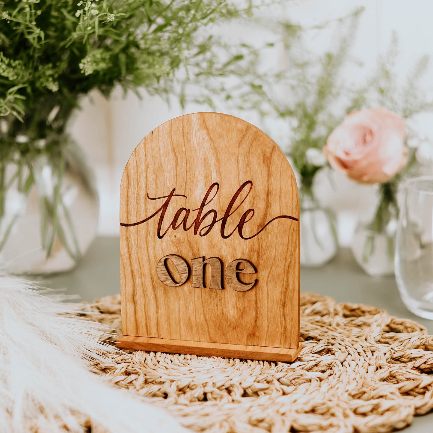 Table number made of solid cherry wood with the word "table" engraved and the word "One" cut out from walnut hardwood.